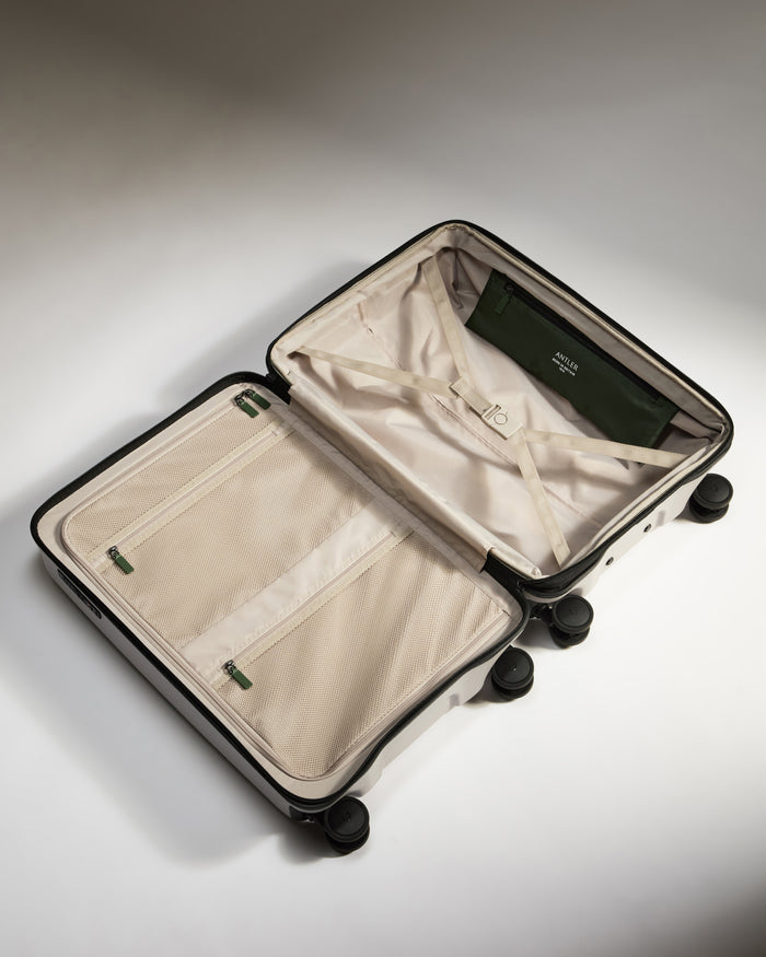 a suitcase with wheels and a green bag