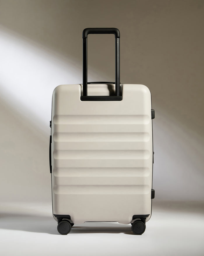 a white suitcase with black handles