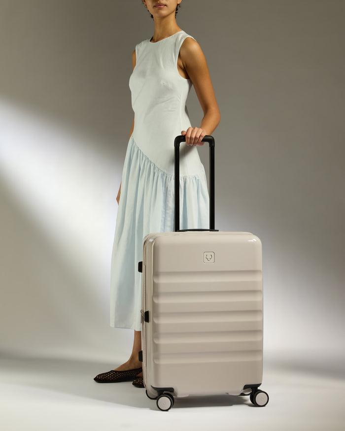 a woman in a white dress holding a suitcase