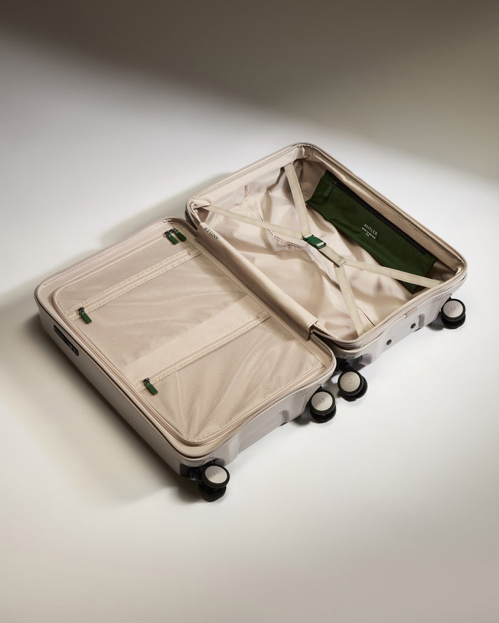 a suitcase with wheels and a green bag
