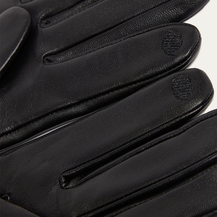 Close-up of black leather gloves with a brand logo on a white background