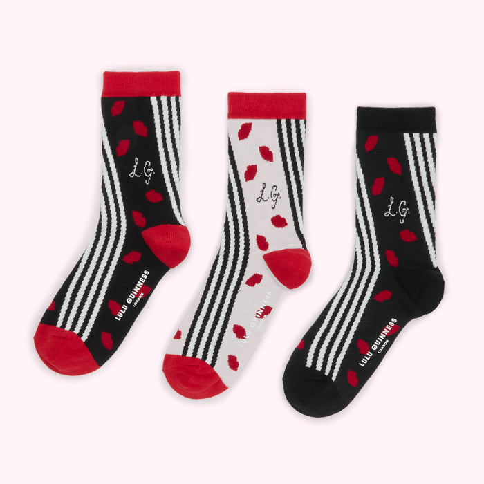 Three pairs of Lulu Guinness socks; black and white striped with red lips and "LG" logo.
