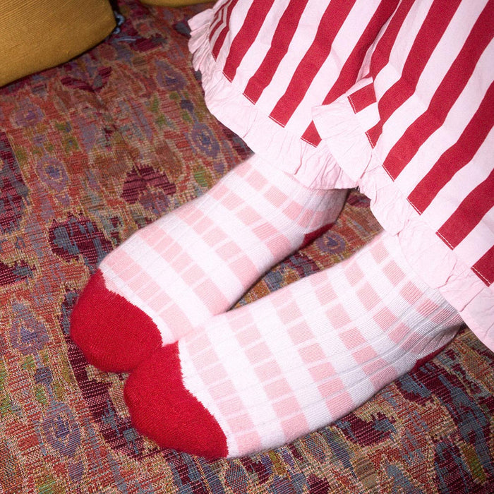 Red and white striped socks on a patterned carpet