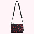 Black crossbody bag with a red and pink lip print.