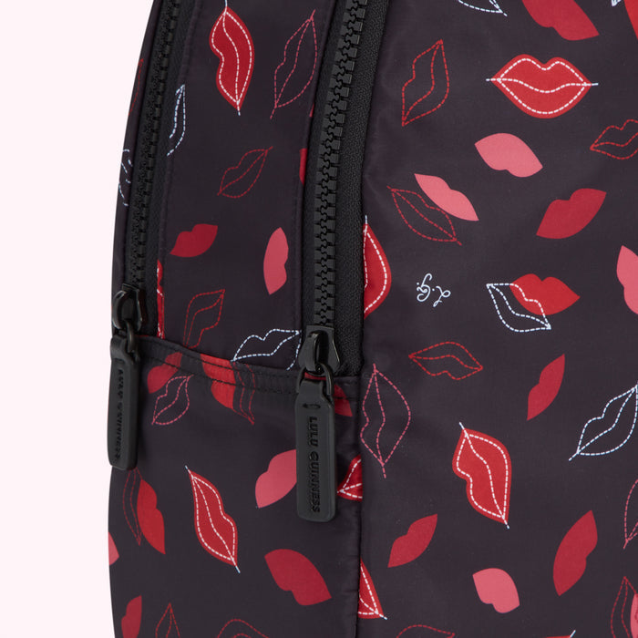 Close-up of a black Lulu Guinness backpack with a lip print.