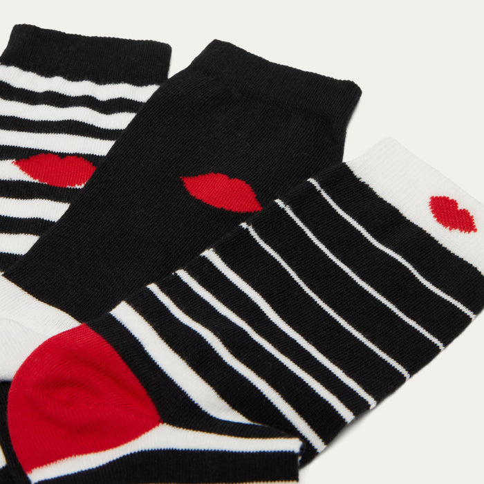 Pairs of socks with black, white, and red design on a light gray background