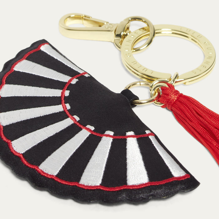 Keychain with black and white striped design and red accents on a white background