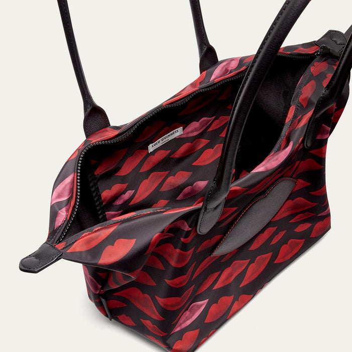 Black and red patterned handbag with visible brand name on a light gray background