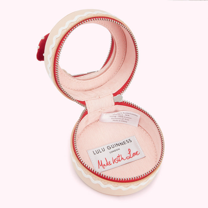 Open Lulu Guinness London "Made with Love" gingerbread-shaped coin purse; pink interior; beige exterior.