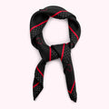 Black silk scarf with red and grey polka dots and stripes, tied in a knot.