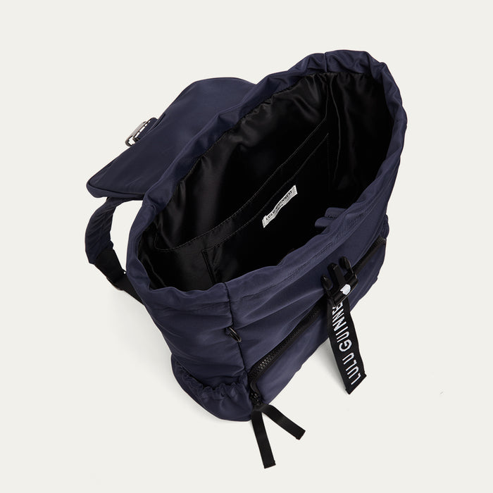 Navy blue backpack open showing the black lining on a light grey background