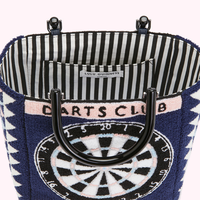 Close-up view of the inside of a Lulu Guinness Darts Club tote bag, showcasing the black and white striped lining and a dark blue exterior with a dartboard design.