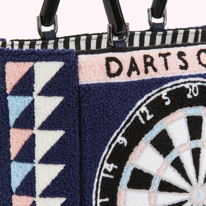 Close-up of a navy blue tote bag with embroidered dartboard and geometric patterns. The bag has black handles.