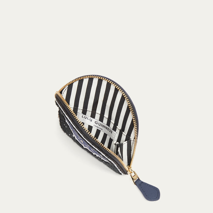 Navy leather coin purse with gold zipper open revealing a striped lining on a white background