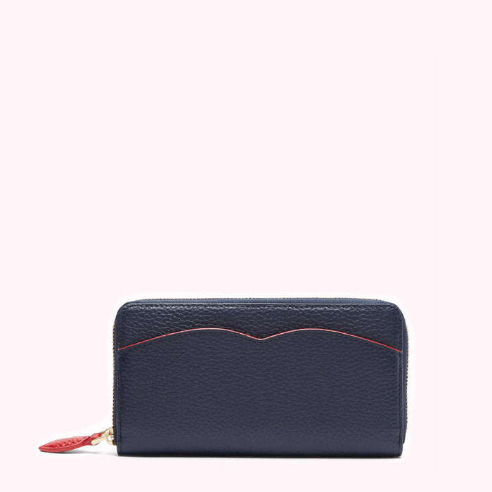 Navy blue leather zip-around wallet with red detailing against a white background.