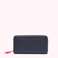 Navy blue leather zip-around wallet with red detailing against a white background.