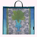 Large teal and blue tote bag with a design of ferns in an urn on a damask background. The bag has black handles and is designed by Annabel Pearl x Lulu Guinness.