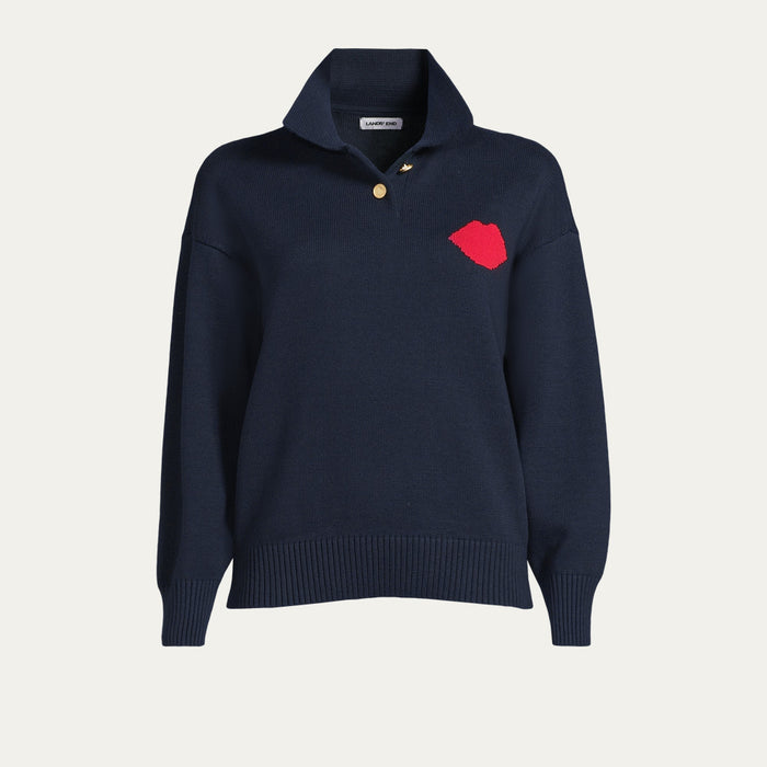 Navy sweater with a red lip on the front  and button up collar on a light gray background