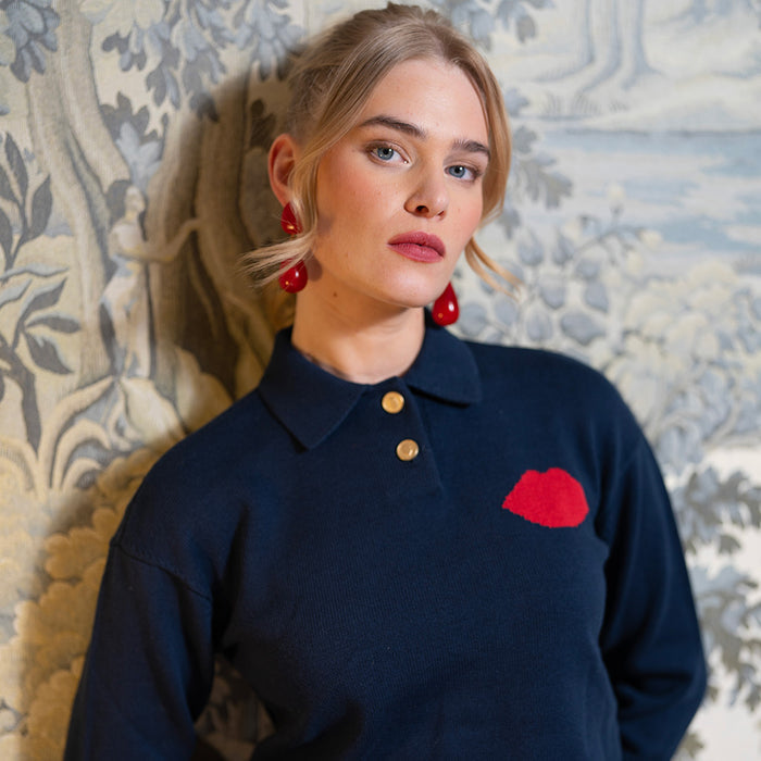 Woman wearing a navy sweater with a red lip design.
