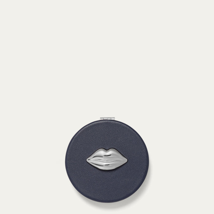 Navy compact mirror with silver lip design on a white background