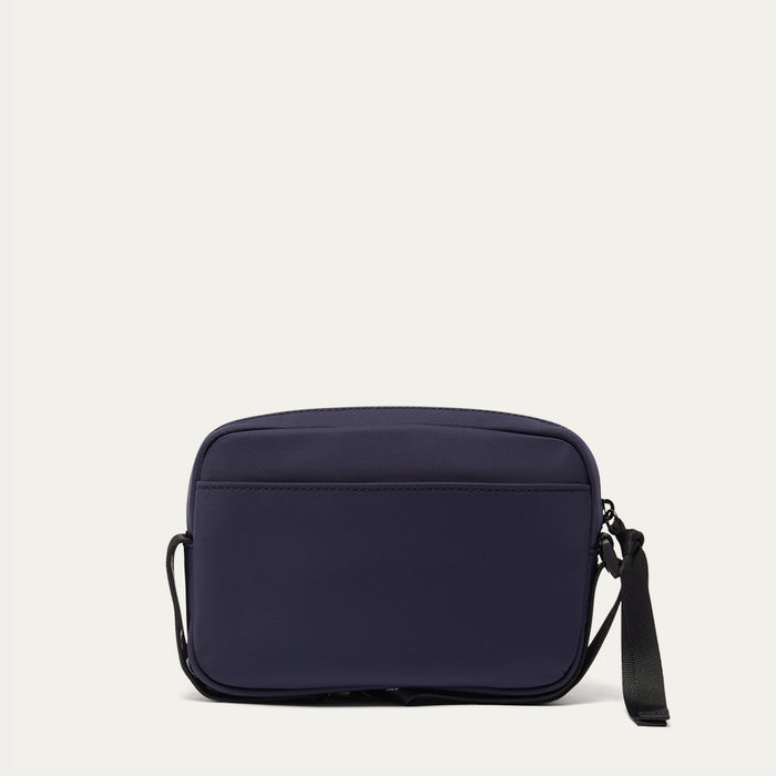 Navy blue crossbody bag on a light grey background