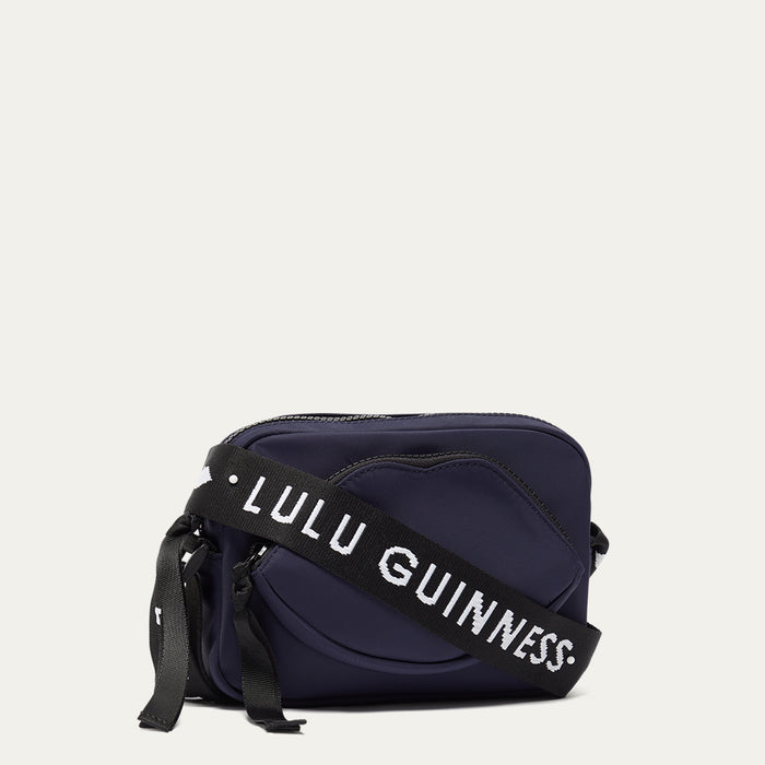 Navy blue bag with a black strap featuring 'Lulu Guinness' on a light grey background