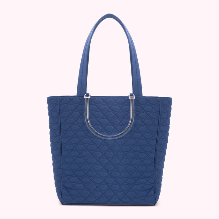 A navy blue quilted tote bag with clear handles.