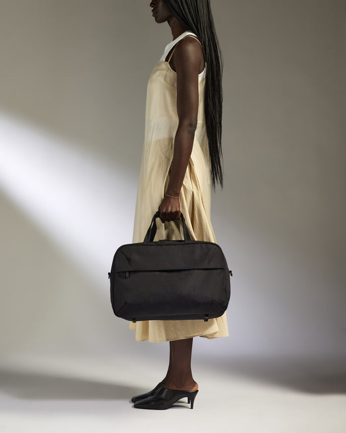 a woman in a dress holding a bag