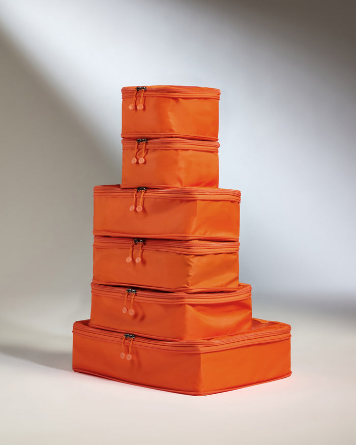 a stack of orange luggage bags