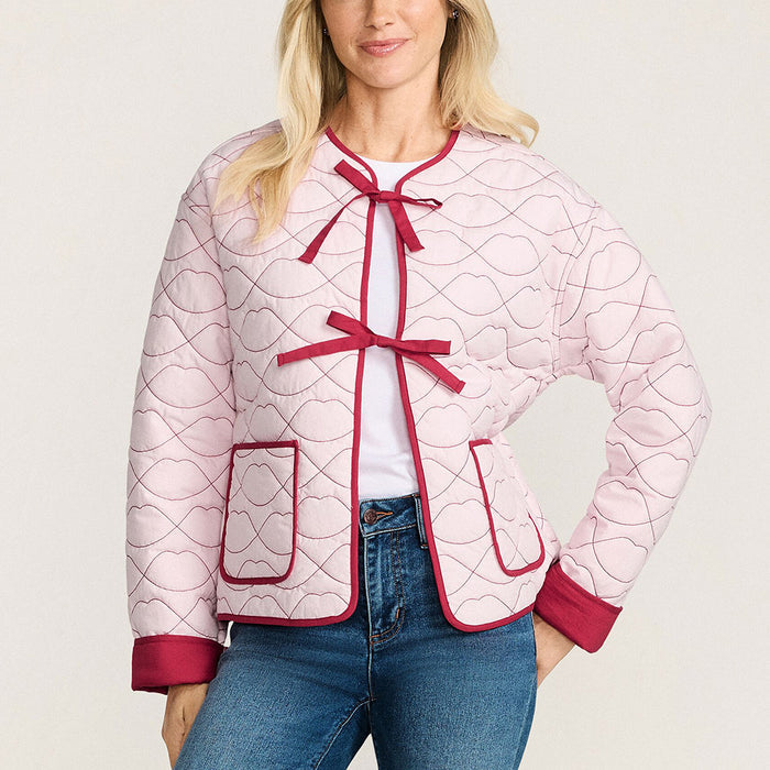 Woman wearing a pink quilted jacket with red lip shaped quilting and trim