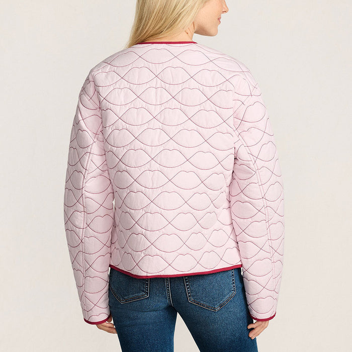 Woman wearing a pink quilted jacket with red lip shaped quilting and trim