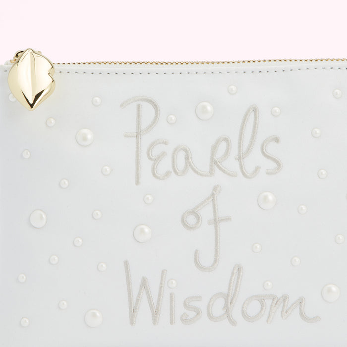 Close-up of a white clutch purse with the words "Pearls of Wisdom" embroidered on it and adorned with small pearls.