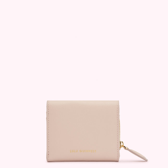 A blush pink Lulu Guinness zip-around wallet against a white background.