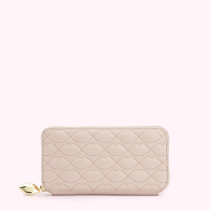 Pale pink quilted zip-around wallet with a lip pattern and gold charm.