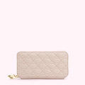 Pale pink quilted zip-around wallet with a lip pattern and gold charm.
