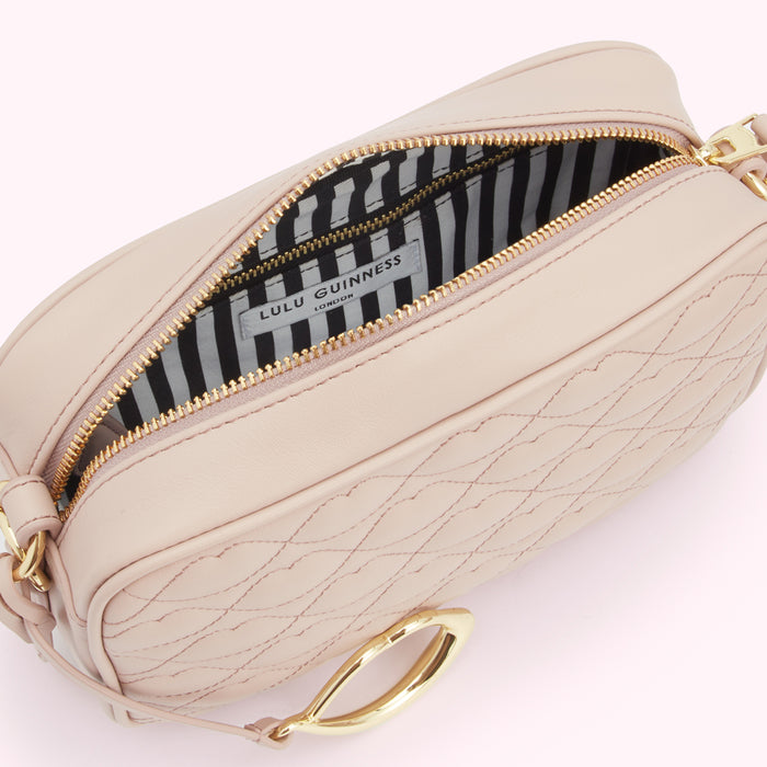 Open blush pink Lulu Guinness London crossbody bag with gold clasp and black and white striped interior.