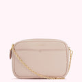 A pale pink leather crossbody bag with a gold chain strap and the brand name "Lulu Guinness" embossed on the front.