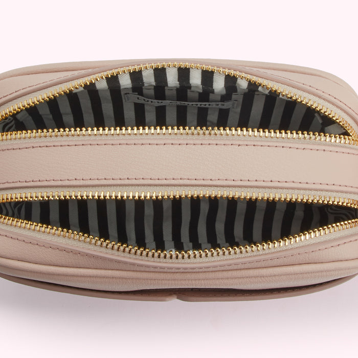 Open blush pink Lulu Guinness crossbody bag with black and white striped interior.