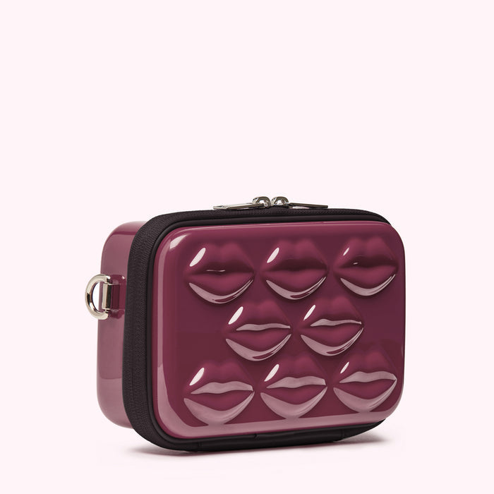 Burgundy-coloured crossbody bag with a glossy finish and embossed lips.