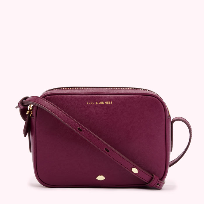 A dark purple Lulu Guinness crossbody bag with a gold zipper and strap.