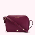 A dark purple Lulu Guinness crossbody bag with a gold zipper and strap.