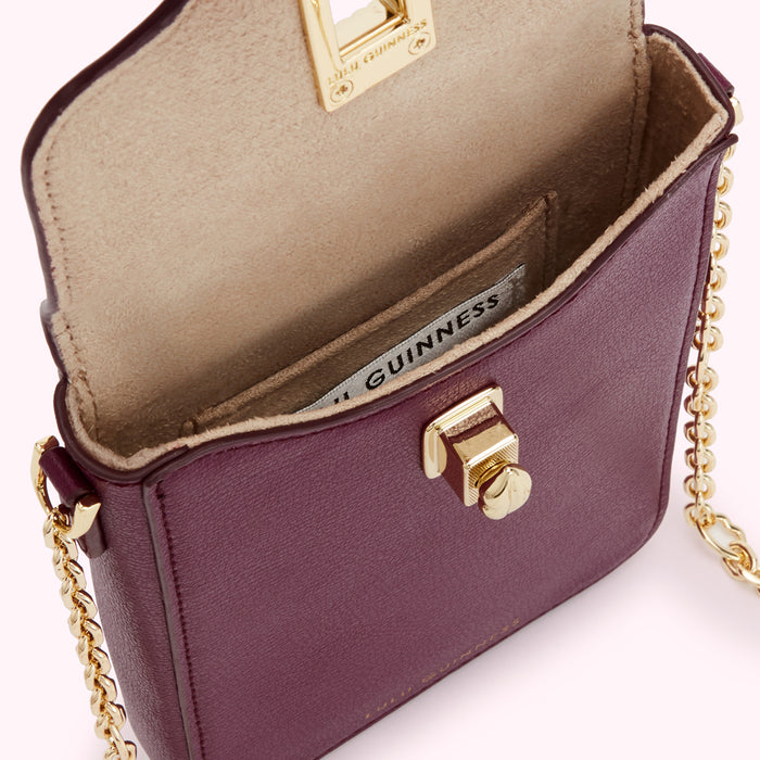 Burgundy Lulu Guinness crossbody bag with gold chain strap and clasp, open to show beige interior and brand label.