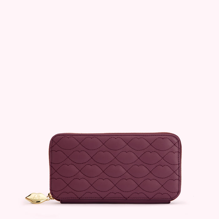 Burgundy quilted zip-around wallet with lip print.