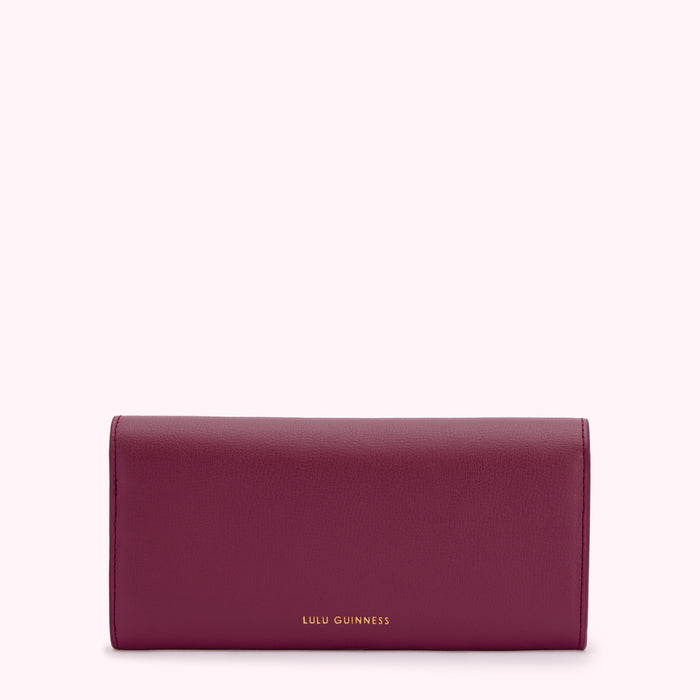 A burgundy Lulu Guinness wallet on a white background.