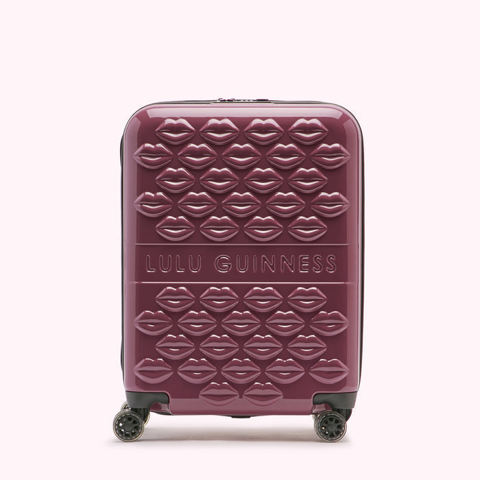A burgundy Lulu Guinness suitcase covered in embossed lips.