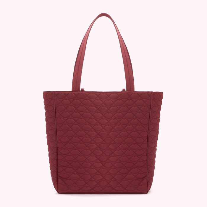 Burgundy quilted tote bag with lip-shaped pattern.