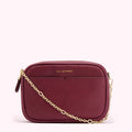 Burgundy snakeskin-textured crossbody bag with gold chain strap and Lulu Guinness logo.