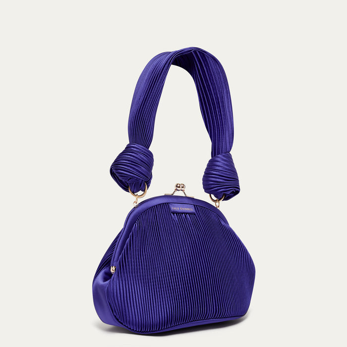 Purple pleated satin handbag on a light gray background
