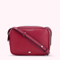 Red Lulu Guinness crossbody bag with silver lip detail.
