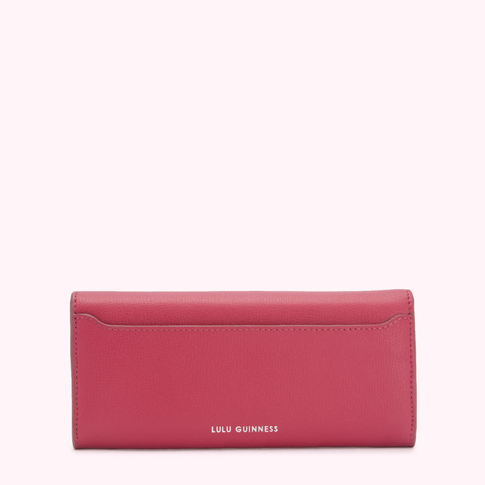 Pink Lulu Guinness wallet on white background.